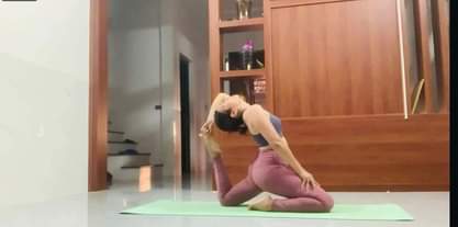 Có thể là hình ảnh về 1 người, đang tập yoga, trang phục thể thao và văn bản